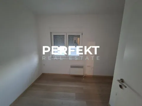 Prazna soba sa belim zidovima, drvenim podom i prozorom. - image 4