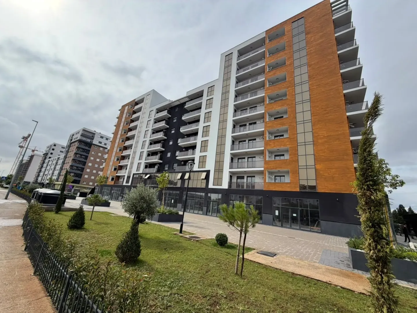 Moderna stambena zgrada sa uređenim dvorištem i terasama.