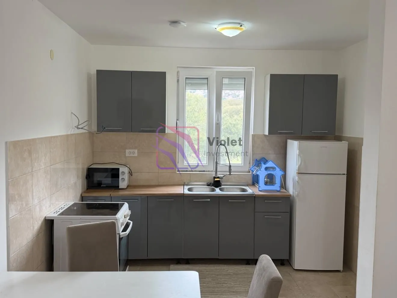 Kitchen with grey cabinets, a sink, and a built-in refrigerator.