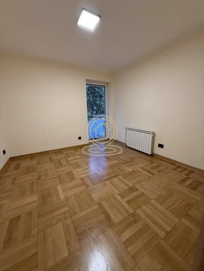 Prazna soba sa parketom i izlazom na terasu.
