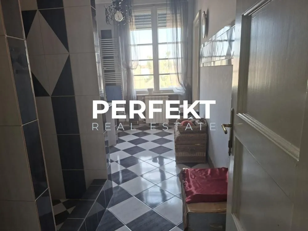Kupatilo sa tuš kabinom i crno-belim keramičkim pločicama na podu.