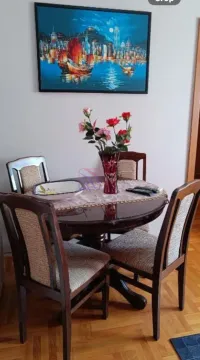 Trpezarijski sto sa stolicama i slikom na zidu. - image 7