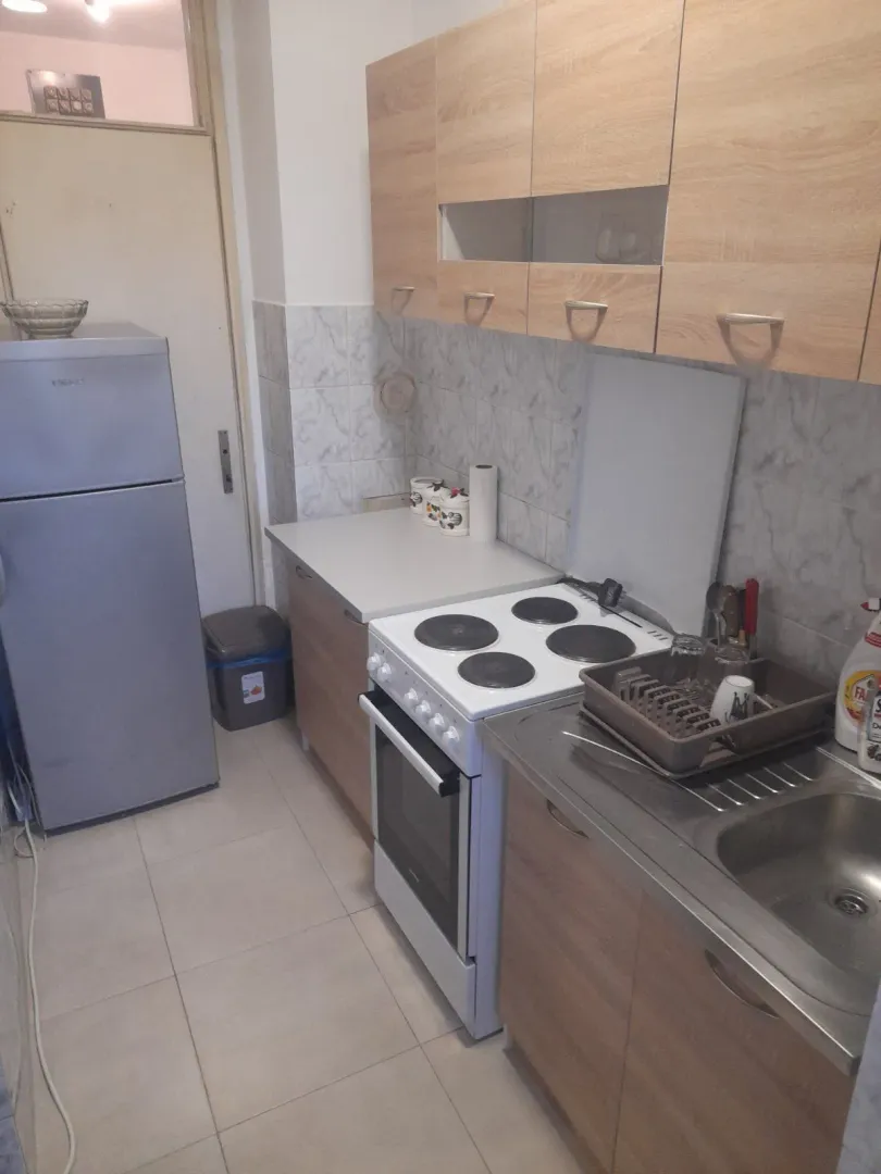 Praktična kuhinja sa svijetlim elementima i aparatima.