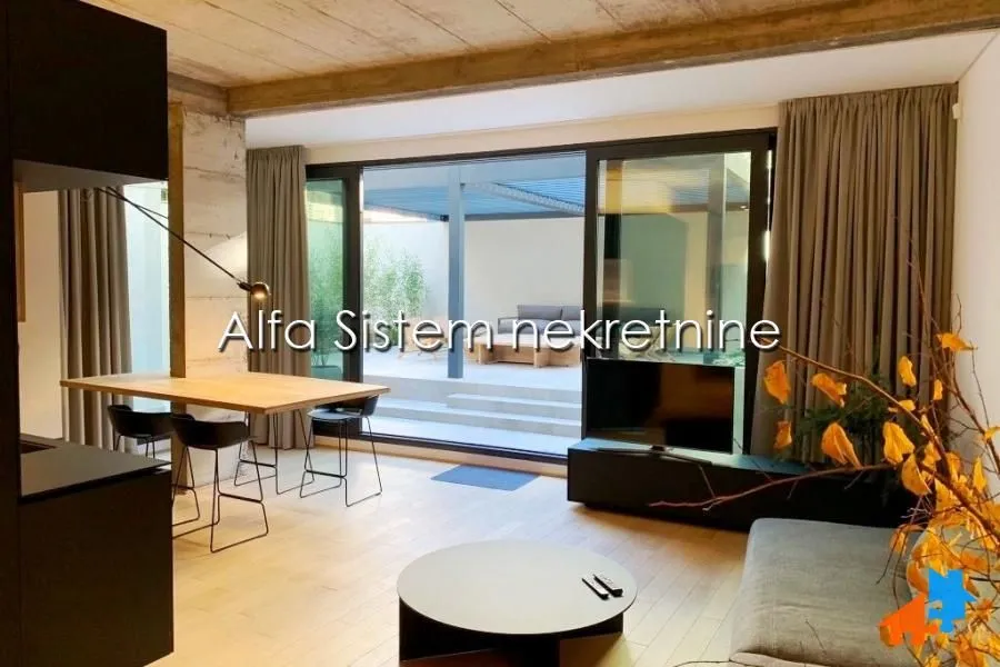Living room with dining area and large glass surfaces with access to the terrace.