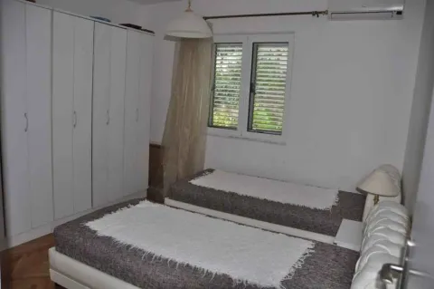 Spavaća soba sa dva singl kreveta i velikim bijelim ormarom. - image 15