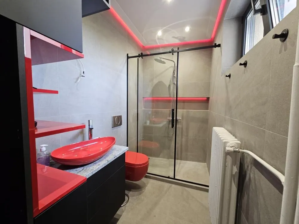 Modern bathroom with red sanitary ware and a walk-in shower.