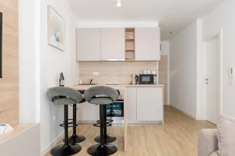 Small modern kitchen with a breakfast bar and bar stools. - image 16