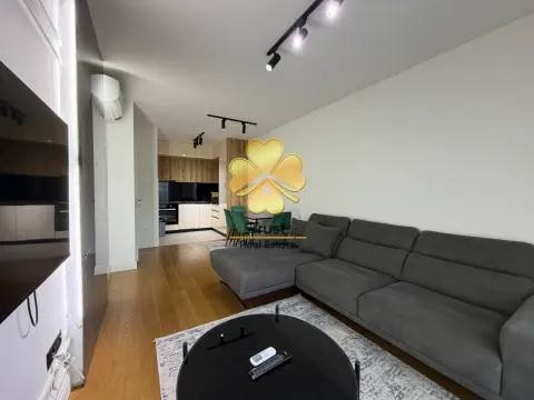Modern living room with a sofa and dining area in the background. - image 3