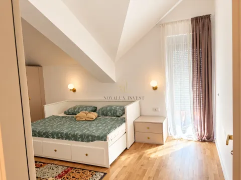 Krovna spavaća soba sa bračnim krevetom, noćnim ormarićem i prozorom sa zavjesama. - image 12