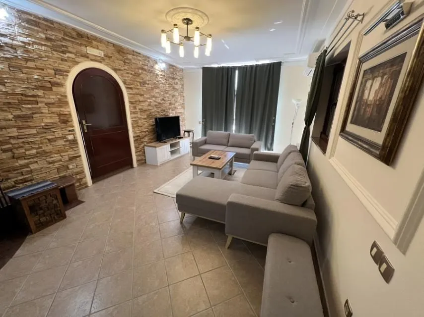 Bright living room featuring comfortable sofas and a decorative stone wall.