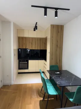 Modern kitchen with a dining table and green chairs. - image 5