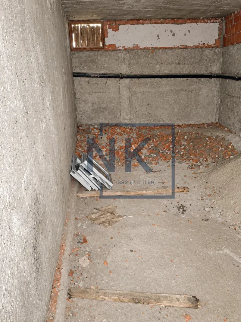 View of an unfinished room in the gray phase of construction with construction waste.