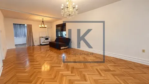 Spacious living room with wooden parquet flooring and a sofa. - image 2