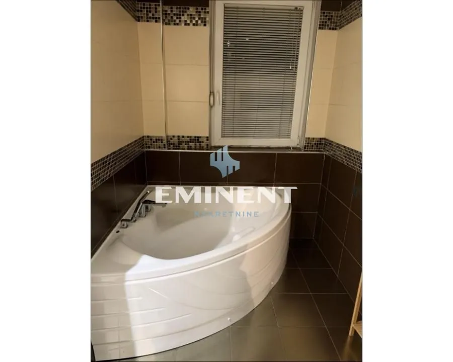 Bathroom equipped with a corner bathtub and ceramic tiles.