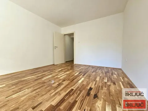 Prazna soba sa drvenim parketom i belim zidovima. - image 8