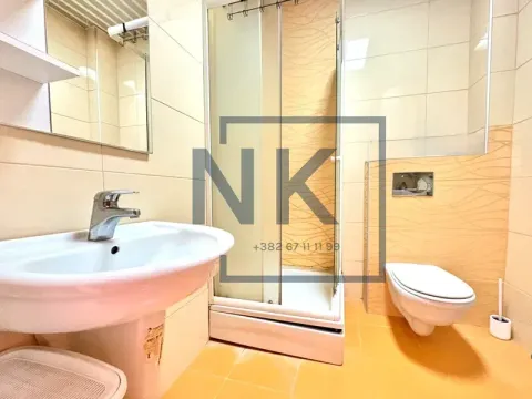 Bathroom equipped with a washbasin, shower cabin, and toilet. - image 5