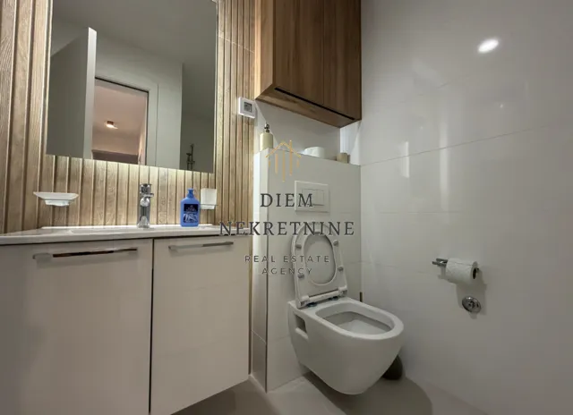 Modern bathroom with white sanitary ware and wooden wall paneling.