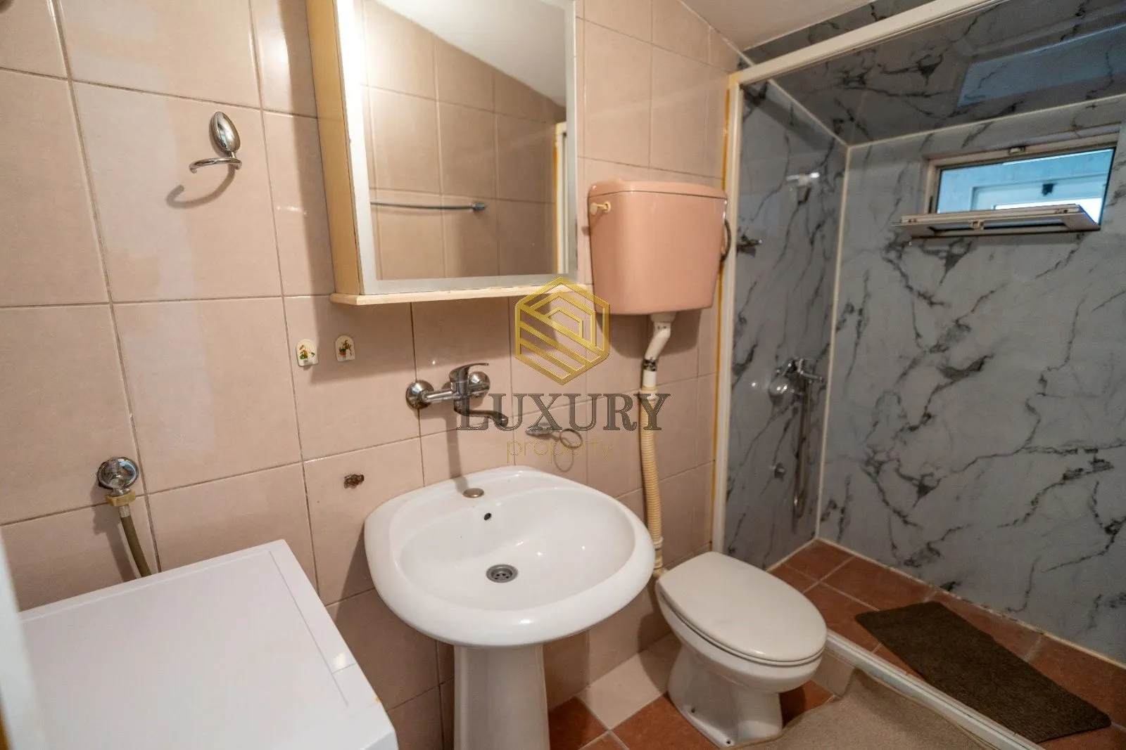 Smaller equipped bathroom with a sink, toilet, and shower cabin.