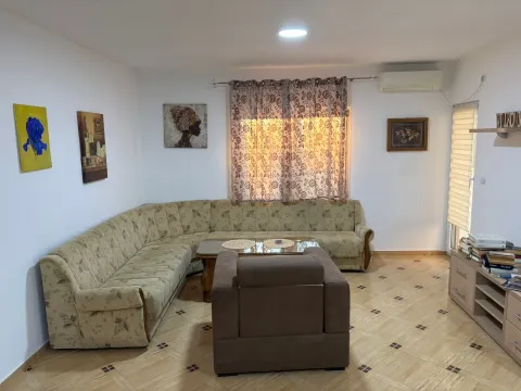 Spacious living room with a corner sofa, armchair, and TV unit. - image 5
