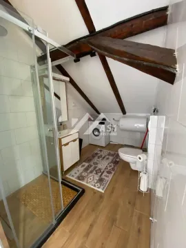 Kupatilo u potkrovlju sa tuš kabinom, WC šoljom i drvenim gredama na plafonu. - image 10