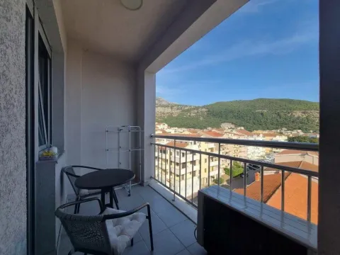 Covered balcony with seating furniture and a view of the town and hills. - image 8