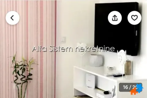 Dnevni boravak sa televizorom na zidu i belom komodom. - image 4