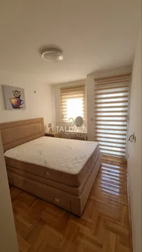 Bedroom with a double bed, hardwood flooring, and windows with blinds. - image 2