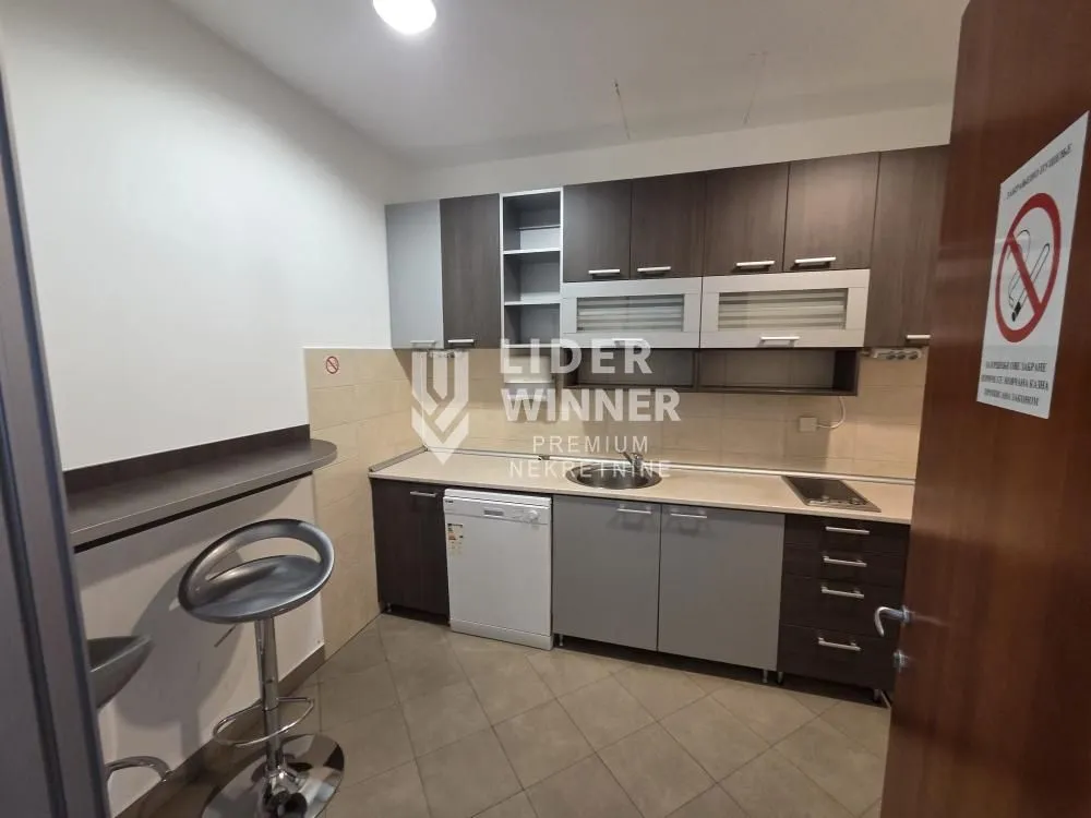 Kitchen with dark cabinetry and a breakfast bar with bar stools.