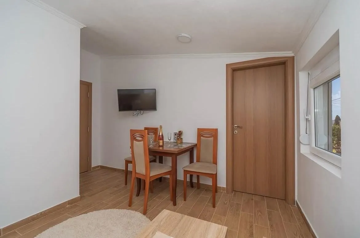 Manji trpezarijski sto sa stolicama u svijetloj prostoriji.