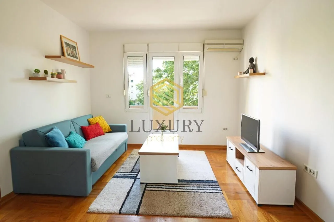 Living room with sofa, TV cabinet and access to the terrace.