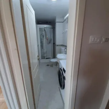 Pogled na kupatilo sa tuš kabinom kroz otvorena vrata. - image 7