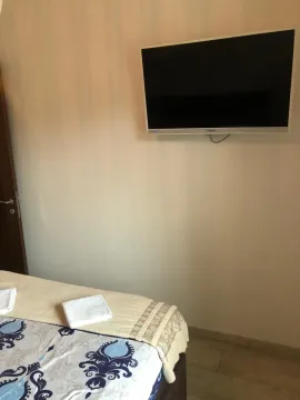 Part of a bedroom with a bed and a TV on the wall. - image 7