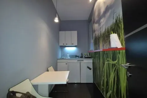Small kitchen with a dining table and grass-themed wallpaper. - image 8