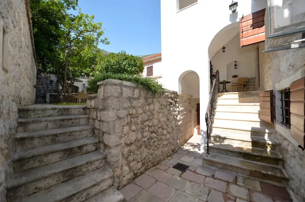 Exterior part of the house with stone stairs and a courtyard.