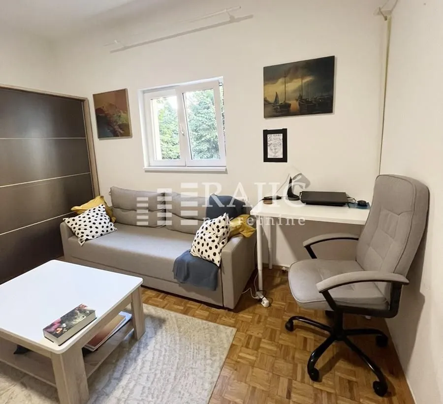 Living room with a sofa, coffee table, and desk.
