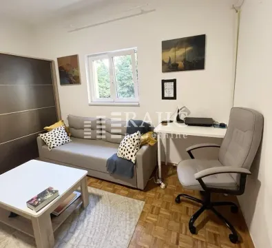 Living room with a sofa, coffee table, and desk. - image 3