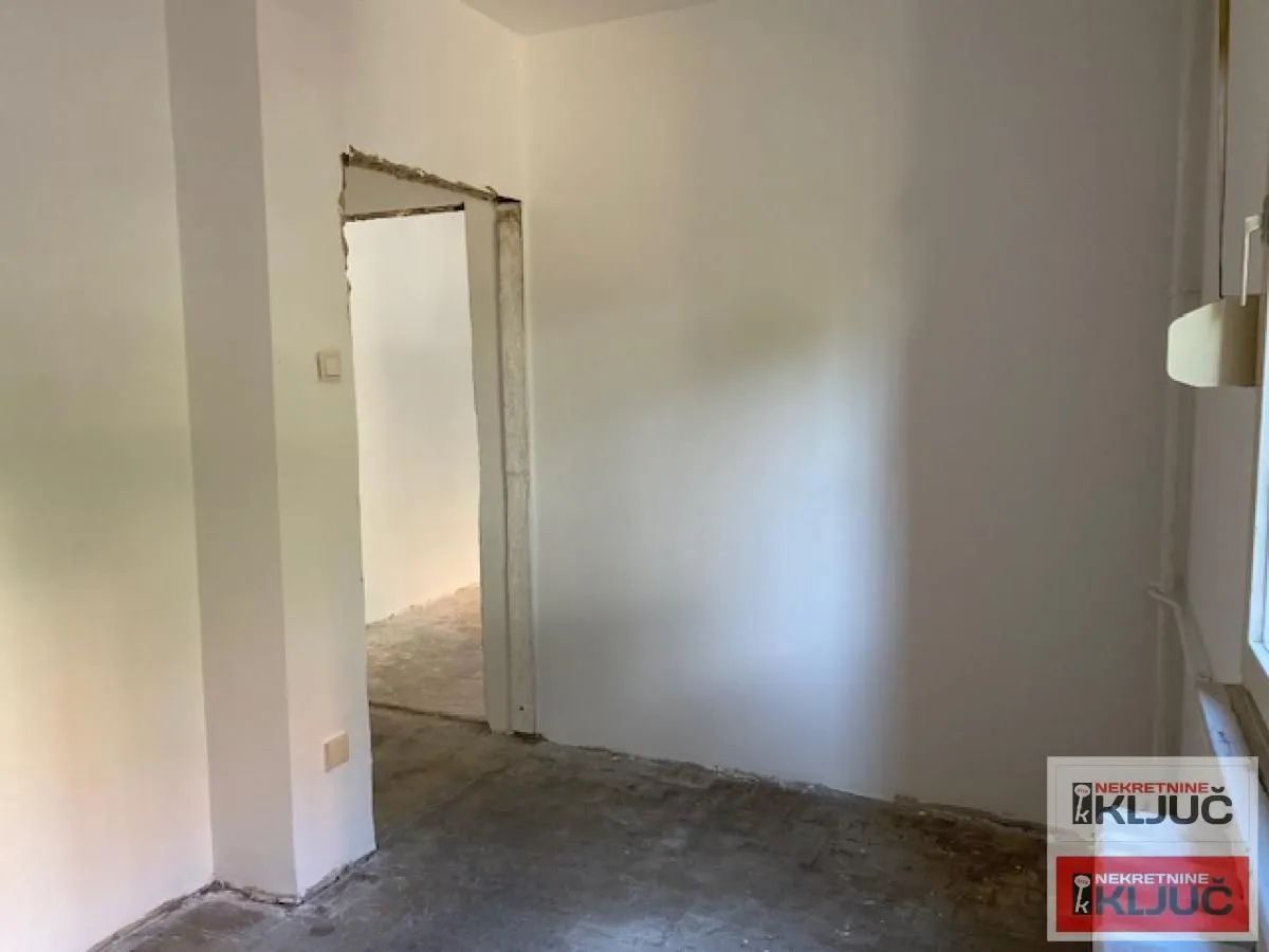 Prazna prostorija sa belim zidovima u fazi renoviranja.