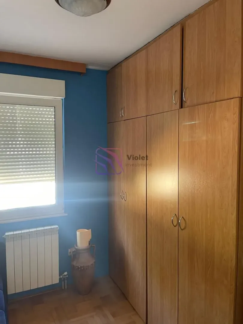 Bedroom with a large wooden wardrobe and a window.