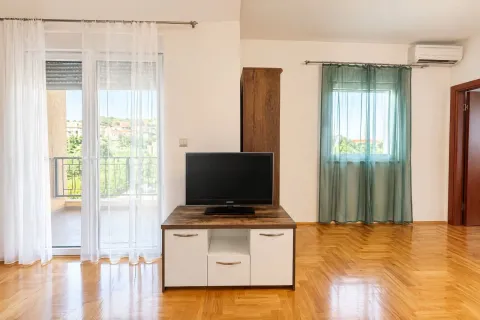 Living room with a TV, wooden parquet flooring, and access to the terrace. - image 6