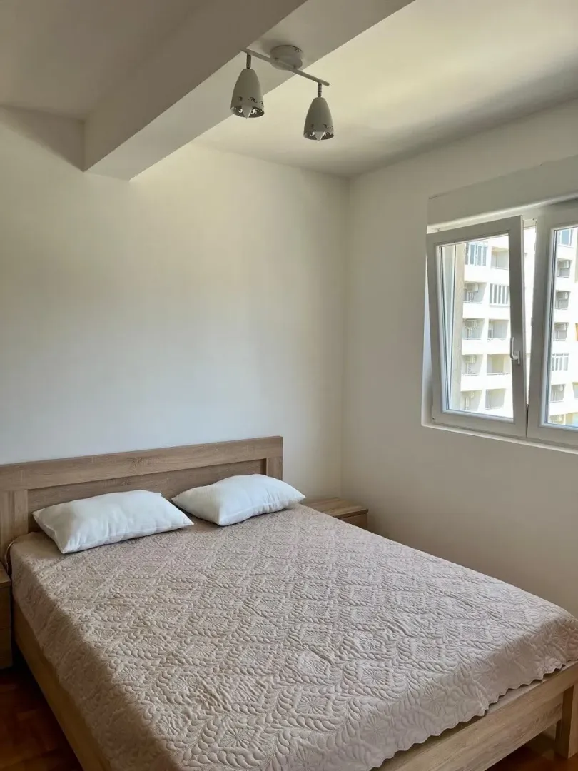 Bright bedroom with a double bed and a window.