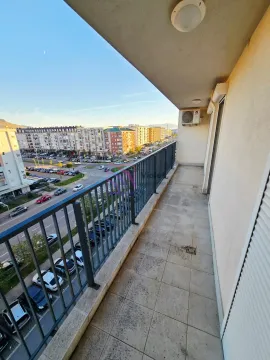Dugačak popločani balkon sa metalnom ogradom i pogledom na grad. - image 14