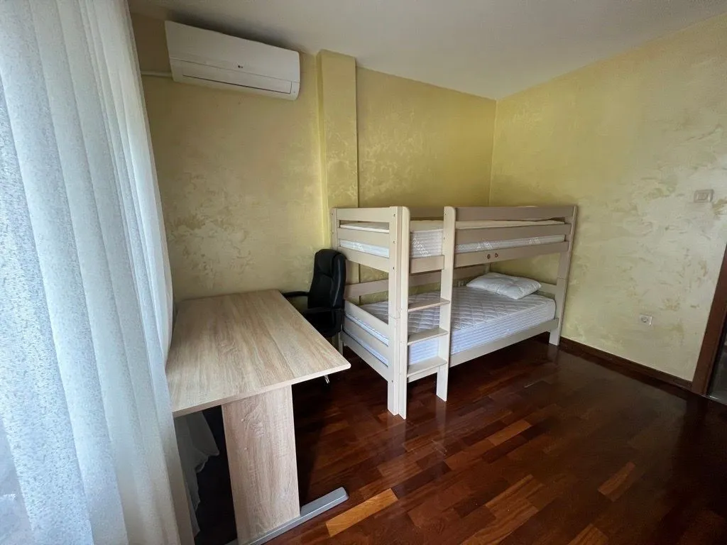 Children's bedroom with a bunk bed and a desk.