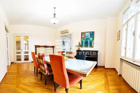 Dining room with a large table, chairs, and parquet flooring. - image 5