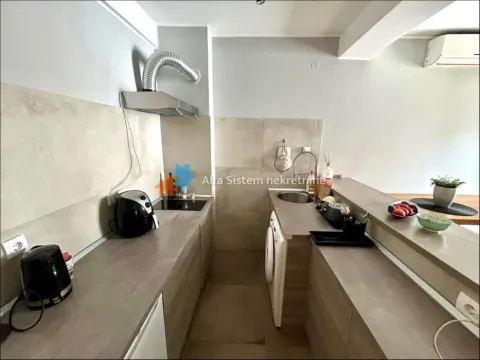 Small kitchen with countertops, a sink, and built-in appliances. - image 16