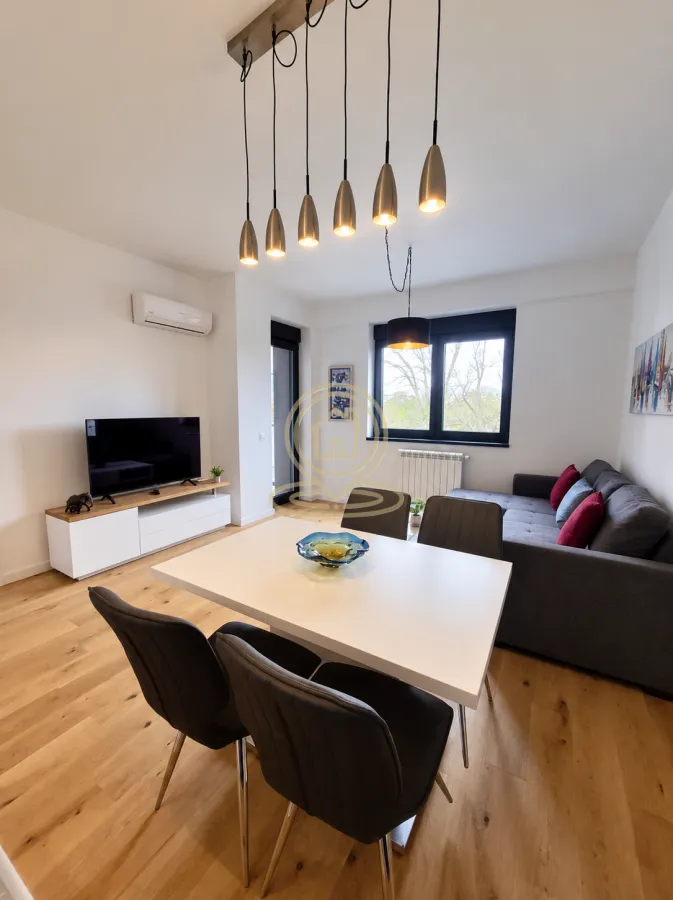 Living room with dining area, sofa and TV.