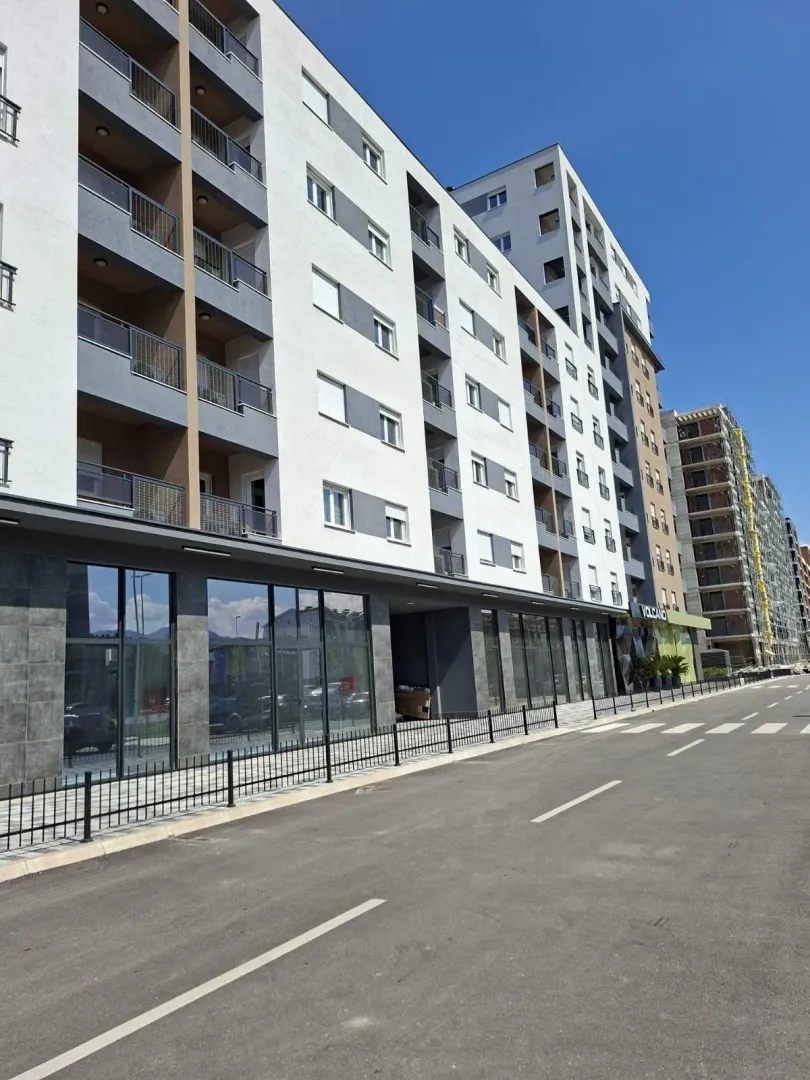 Exterior of a modern residential building with commercial spaces on the ground floor.