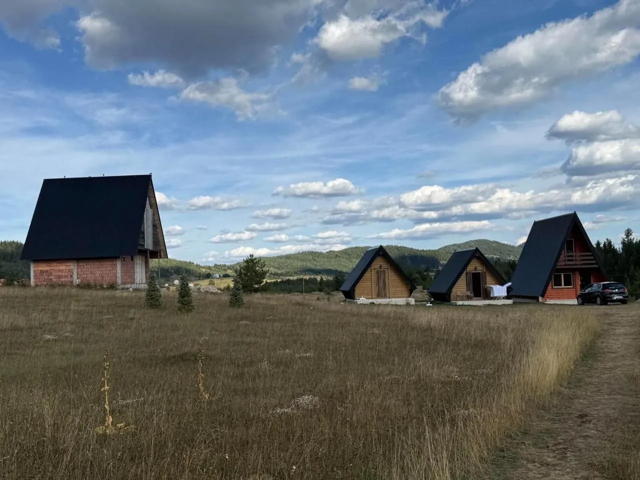 Pogled na drvene vikendice i prirodu u okolini.