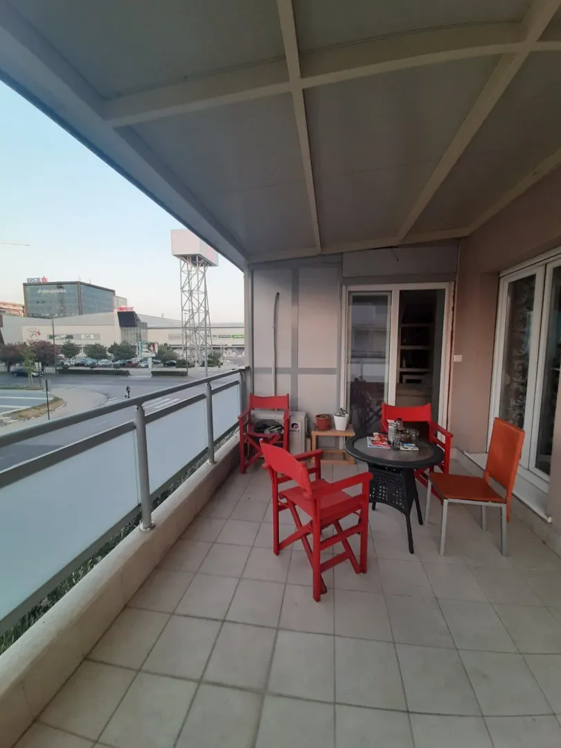 Spacious terrace with outdoor furniture and a city view.