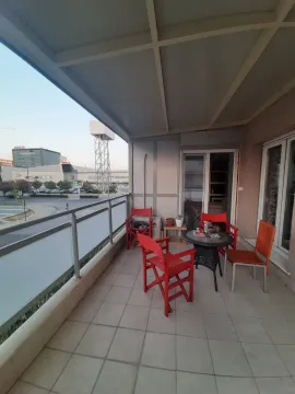 Spacious terrace with outdoor furniture and a city view. - image 4