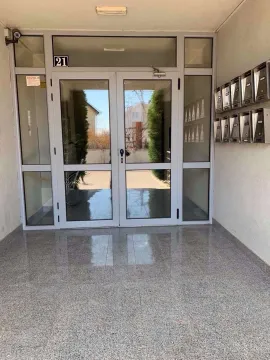 Ulaz u stambenu zgradu sa staklenim vratima i poštanskim sandučićima. - image 2